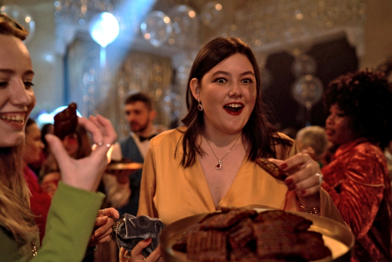 Group of people in which a girl eating chocolate in the night party