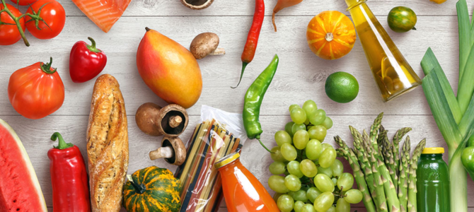 A grey wood countertop with a selection of colourful fruit and vegetables.