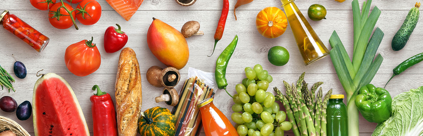 A grey wood countertop with a selection of colourful fruit and vegetables.